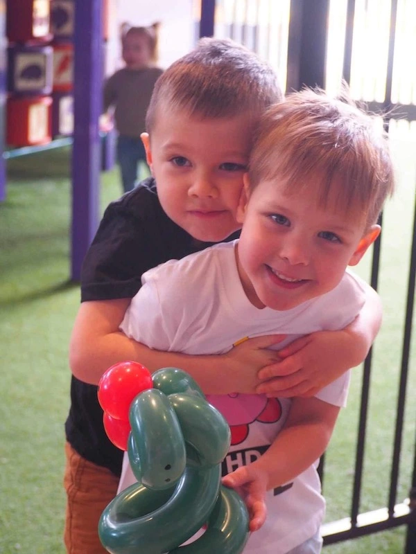 two boys with a balloon snake